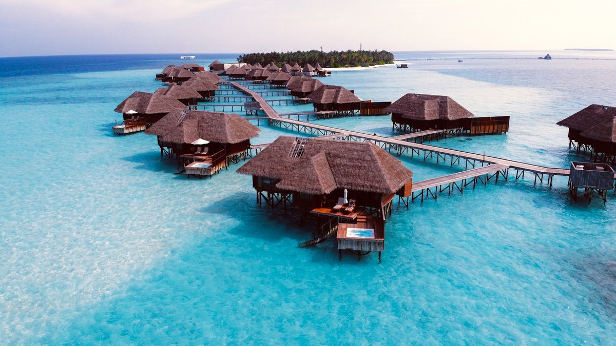 Vannbungalow over turkis lagune paa Maldivene