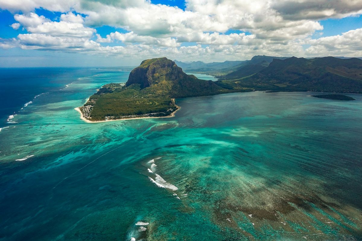 Strand og fjell paa Mauritius med turkis lagune