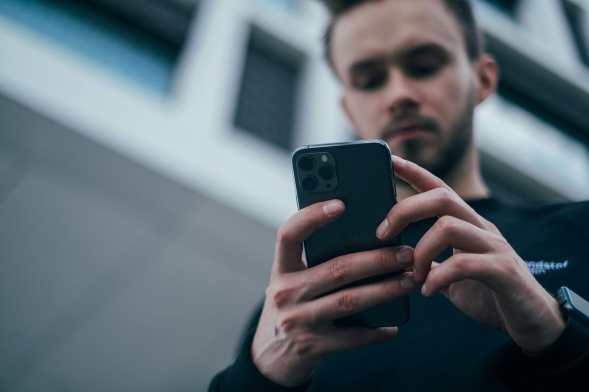 Ung mann gransker innhold på mobilskjermen