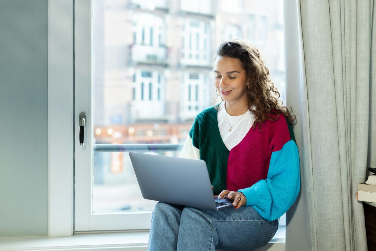 Person som jobber på laptop i en vinduskarm