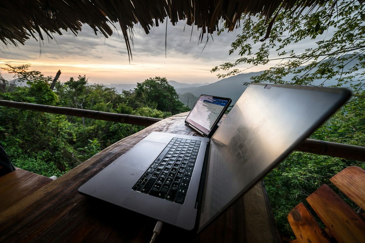 Laptop og mobil med utsikt pa reise