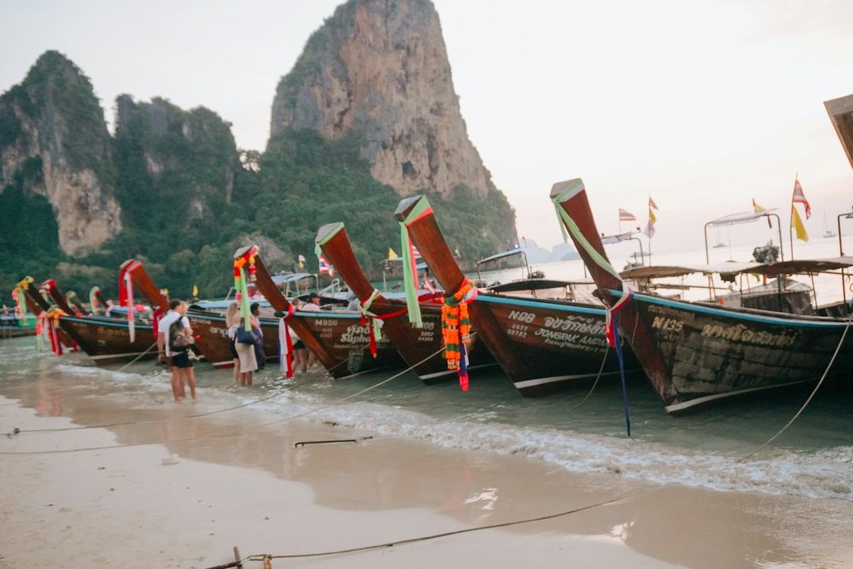 Longtail-bater langs en tropisk strand i Thailand