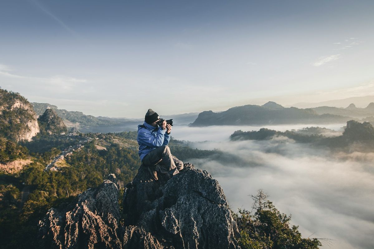 Fotograf tar bilder fra en fjelltopp