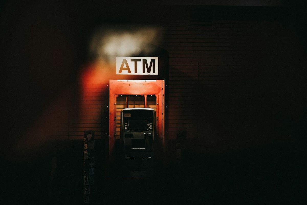 Opplyst minibank med ATM-skilt om natten