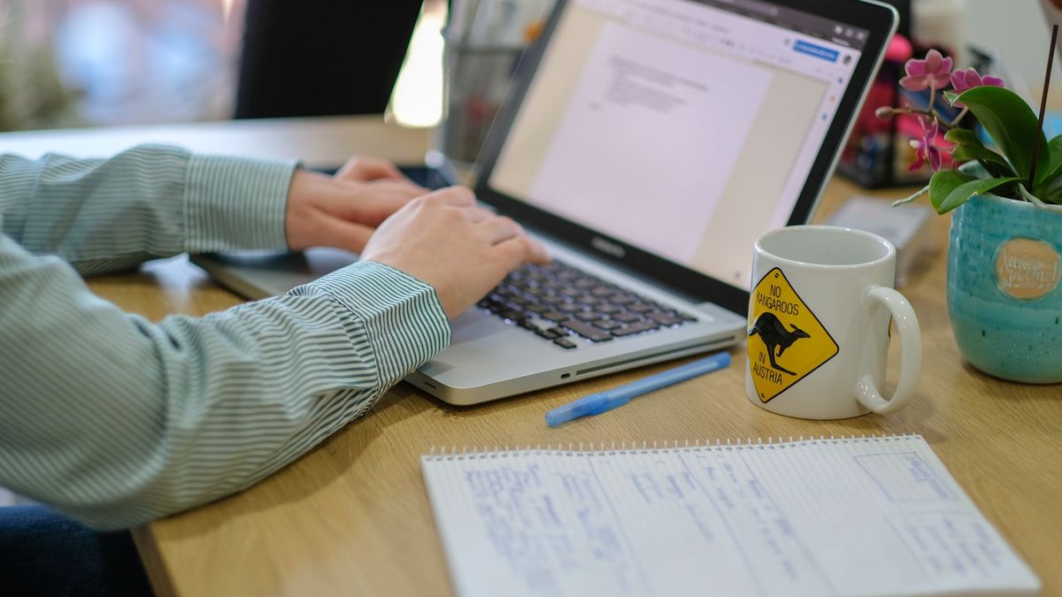 Person ved bord som sammenligner forsikring pa laptop