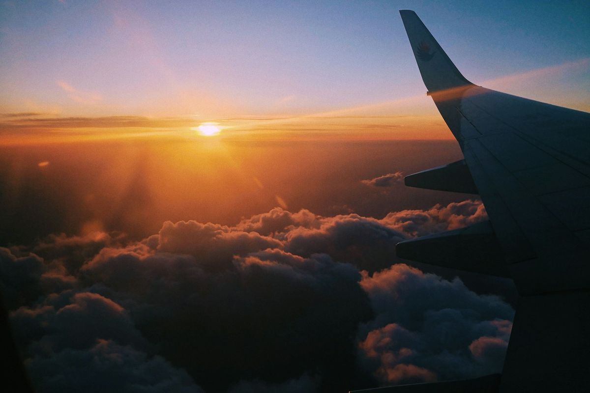 Fly over skyene i gyllent lys