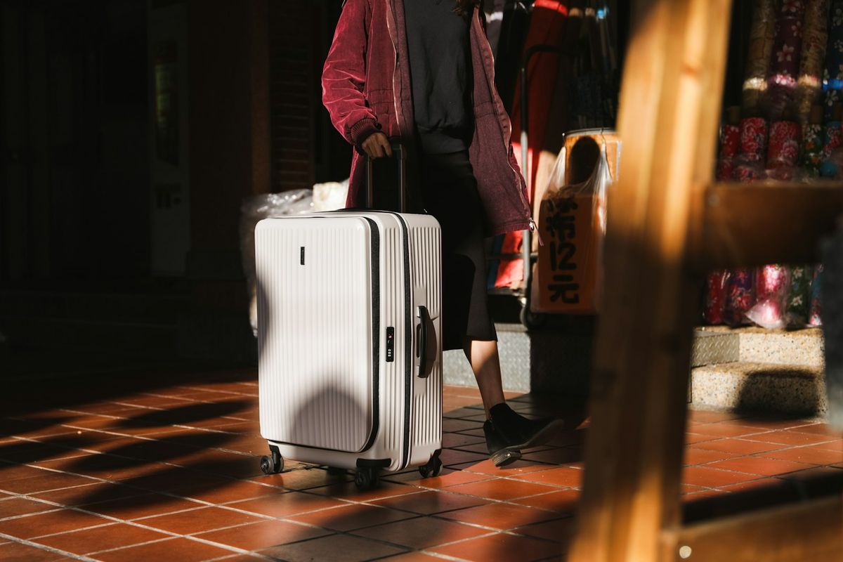 Reisende med kabinkoffert på vei gjennom flyplassen