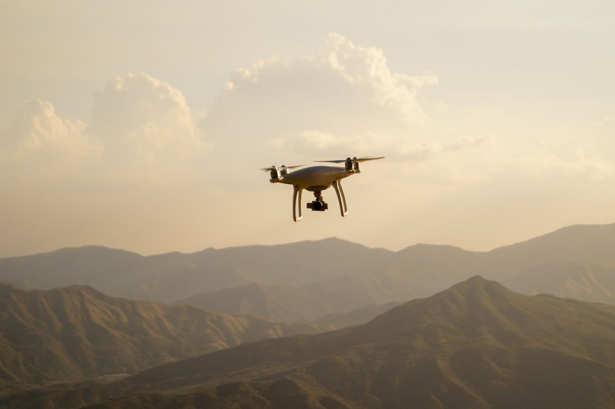Svart drone som flyr over fjell