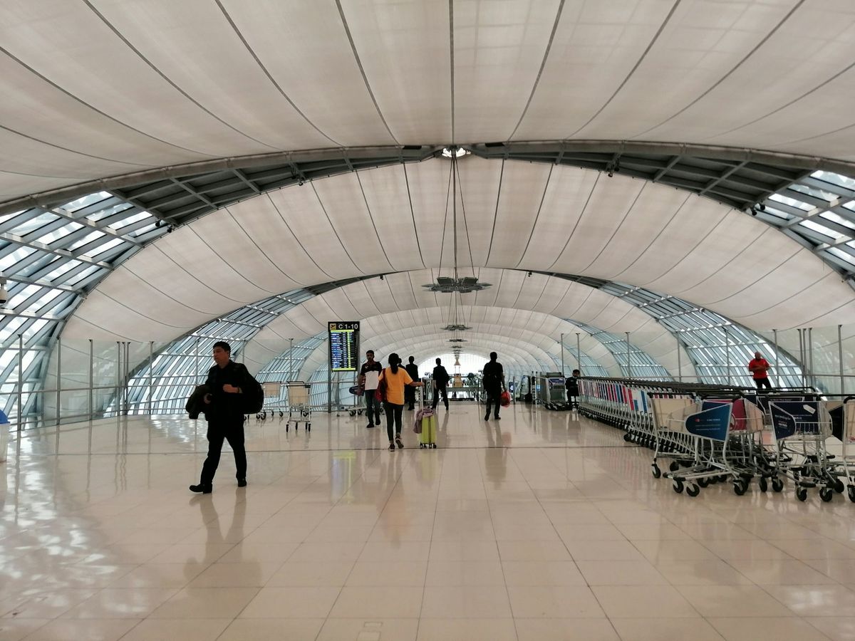 Reisende med bagasje i terminalen på Suvarnabhumi-flyplassen i Bangkok